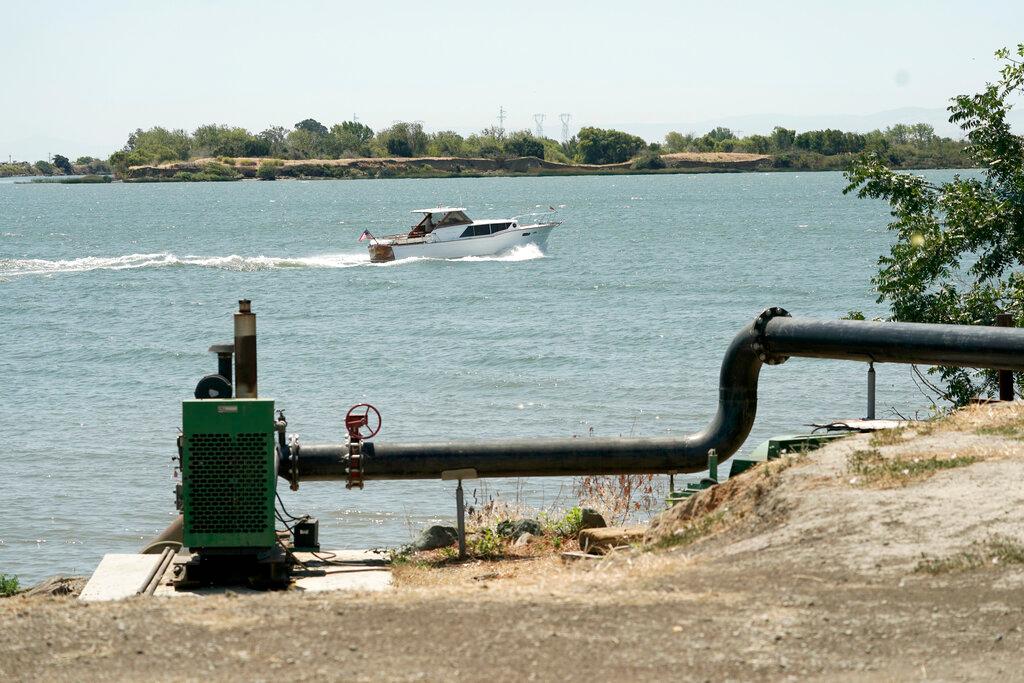 A boat passes a pump used to draw irrigation water from the Sacramento River for the land owned by farmer Al Medvitz in Rio Vista, Calif.