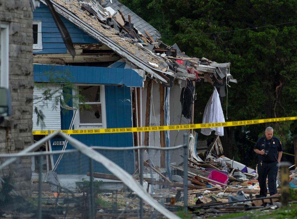 A utility worker walks near a home that exploded in Evansville, Ind.