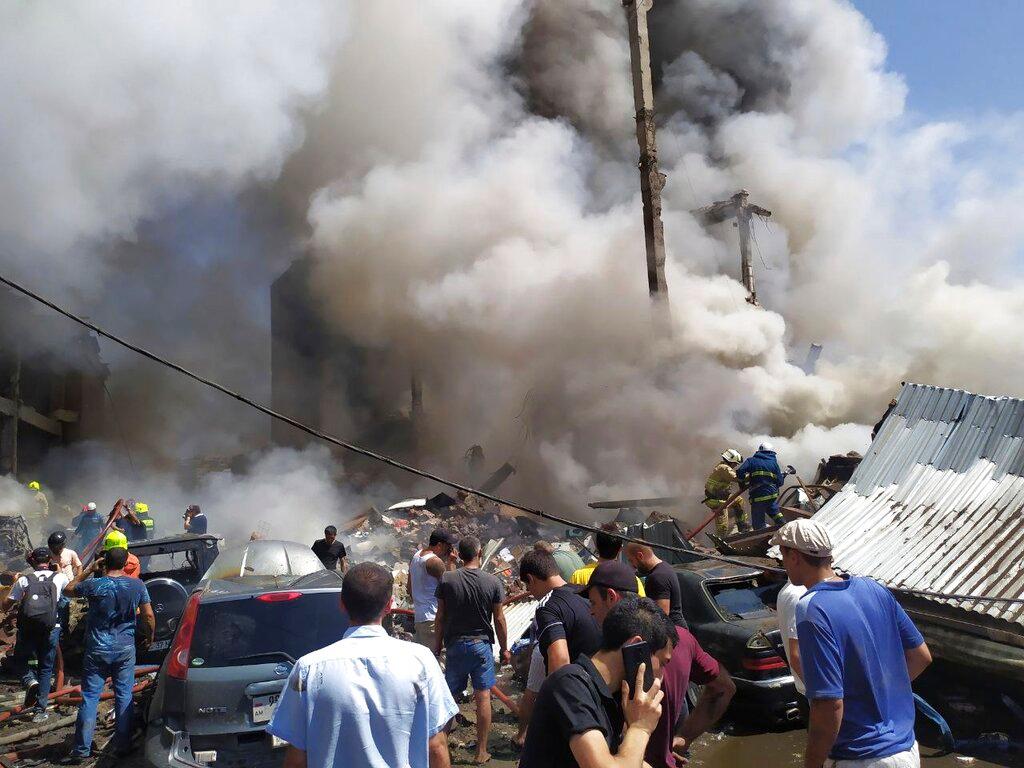 Image shows smoke from explosion people at the scene 