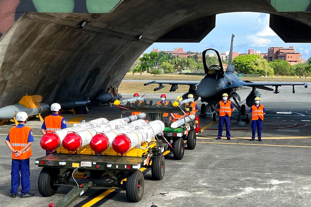 Military personnel stand next to Harpoon A-84, anti-ship missiles and AIM-120 and AIM-9 air-to-air missiles prepared for a weapon loading drills in front of a F16V fighter jet at the Hualien Airbase in Taiwan