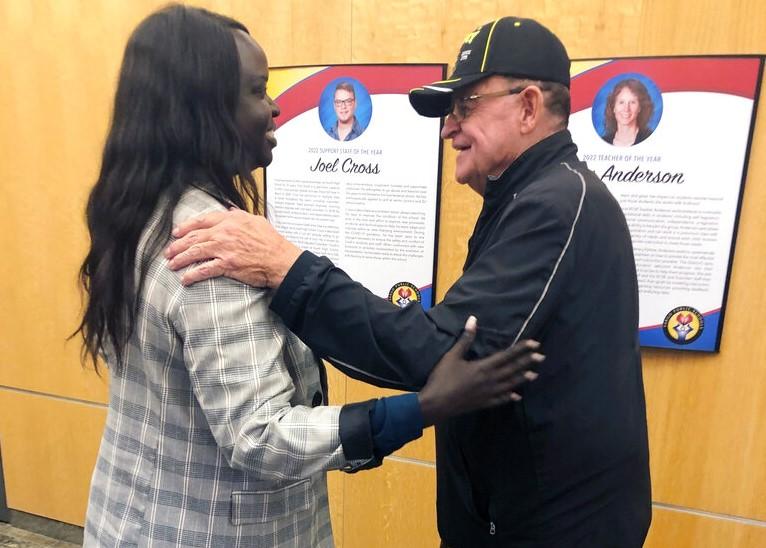 Nyamal Dei, a school board member in Fargo, N.D., is greeted by Vietnam veteran David Halcrow following a special meeting