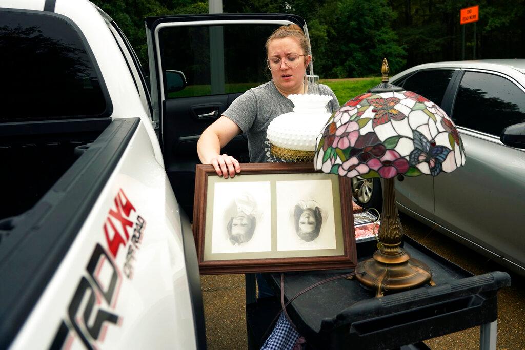 Courtney Ingle loads some of her grandmother's possessions into her truck Wednesday, Aug. 24, 2022, after floodwaters had receded at the Peach Tree Village nursing home where she lives in Brandon, Miss.