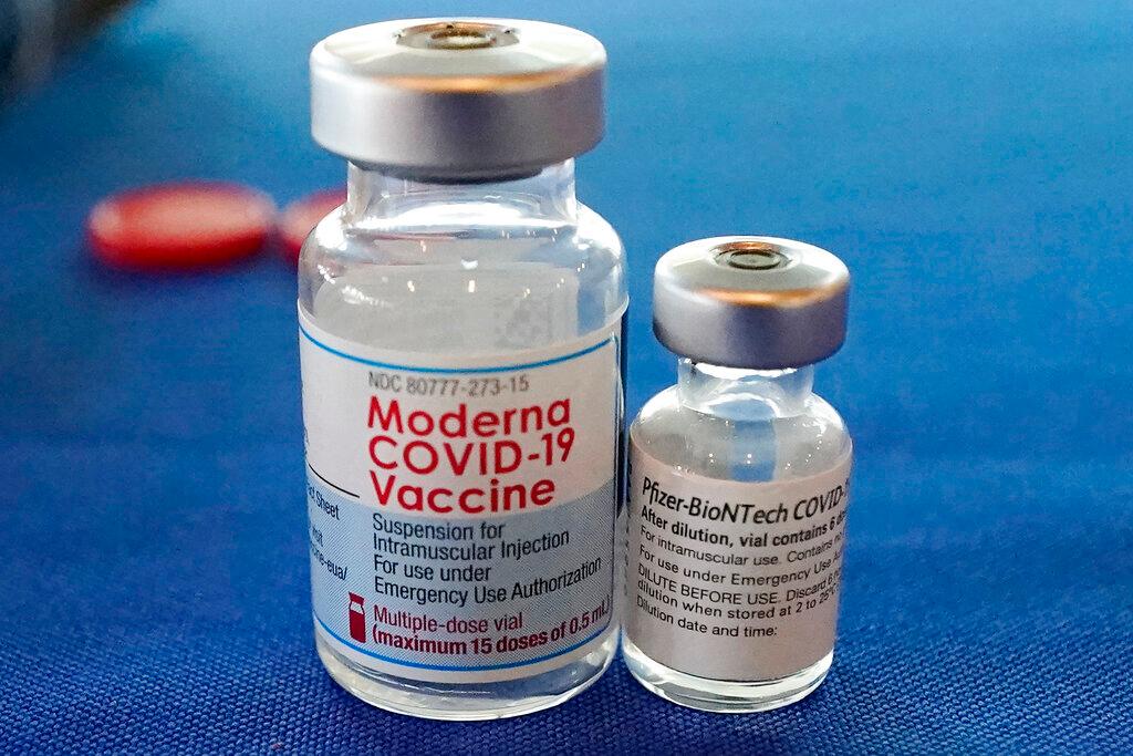 Two vials of vaccine different sizes from two different companies.