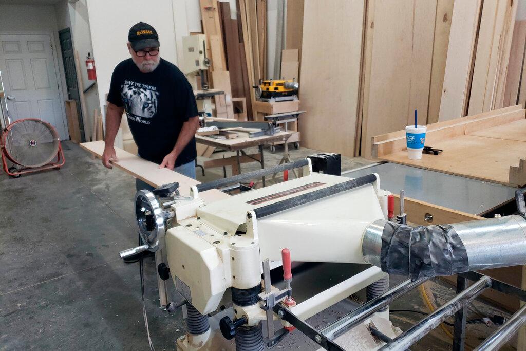 Man cutting pieces of lumber on electric saw
