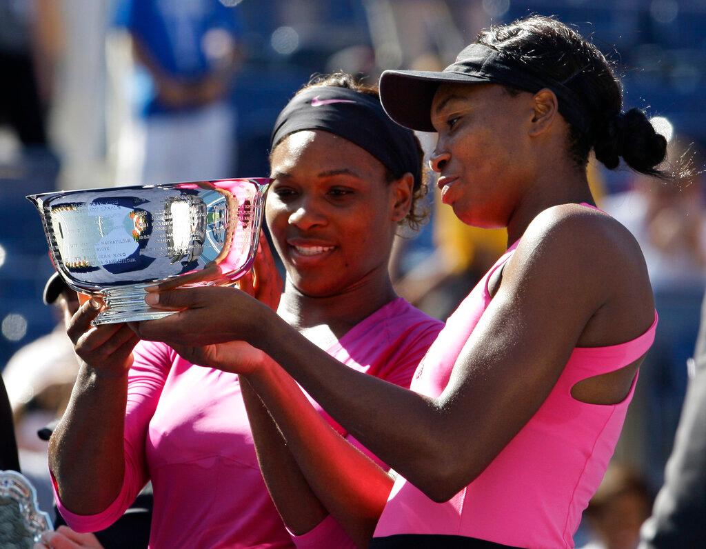 The two sisters looking over trophy after a win.