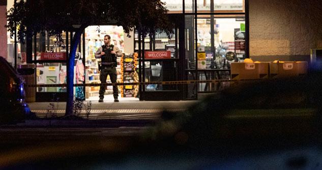 Police officer inside of a grocery store doorway