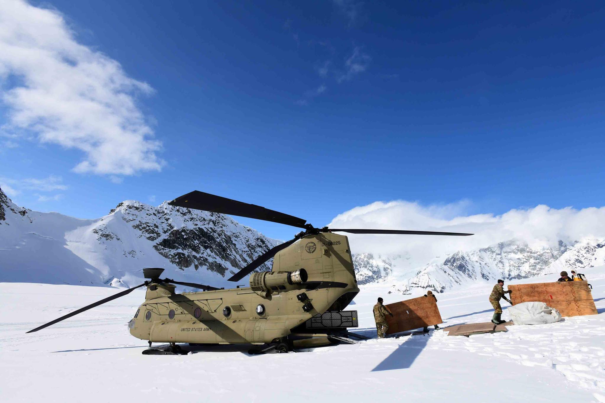 Soldiers and National Park Service personnel offload equipment and supplies from a U.S. Army CH-47 Chinook helicopter on Kahiltna Glacier on April 27, 2022.