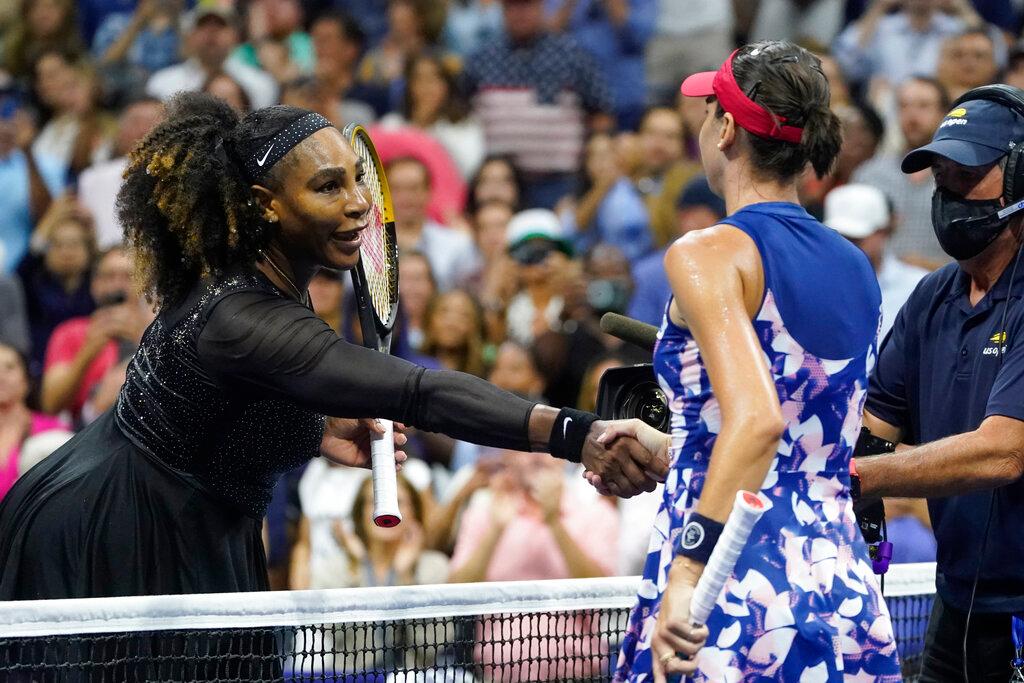 two woman shaking hands over tennis net