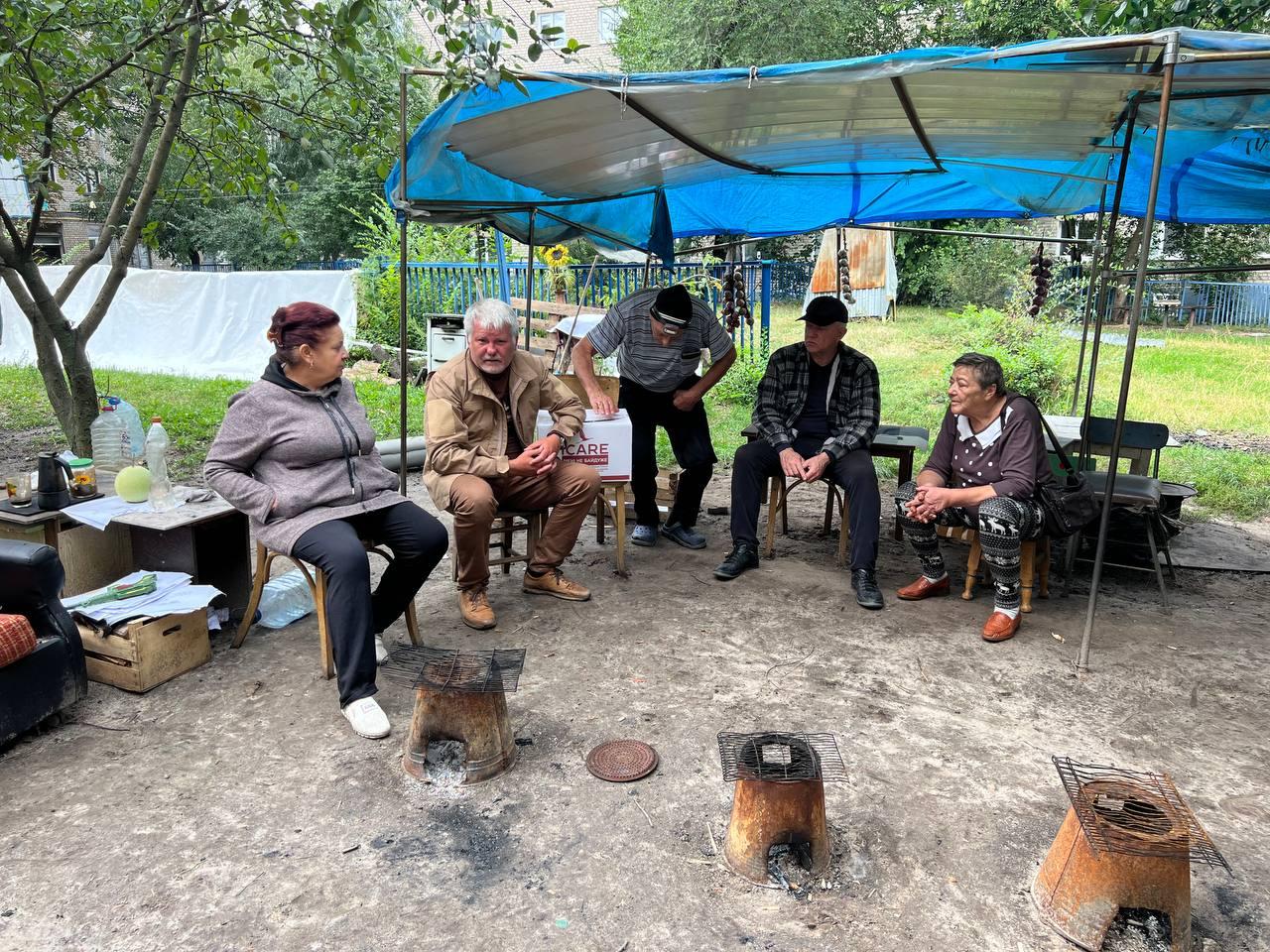 Residents of an apartment complex in Izyum, with their makeshift iron bucket stoves nearby, meet with Denis Geronkov, Mission Eurasia, just a few days after they were liberated from Russian occupation.