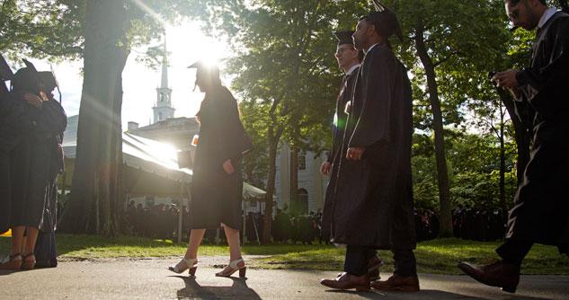 People walking outside in graduation cap and gown.