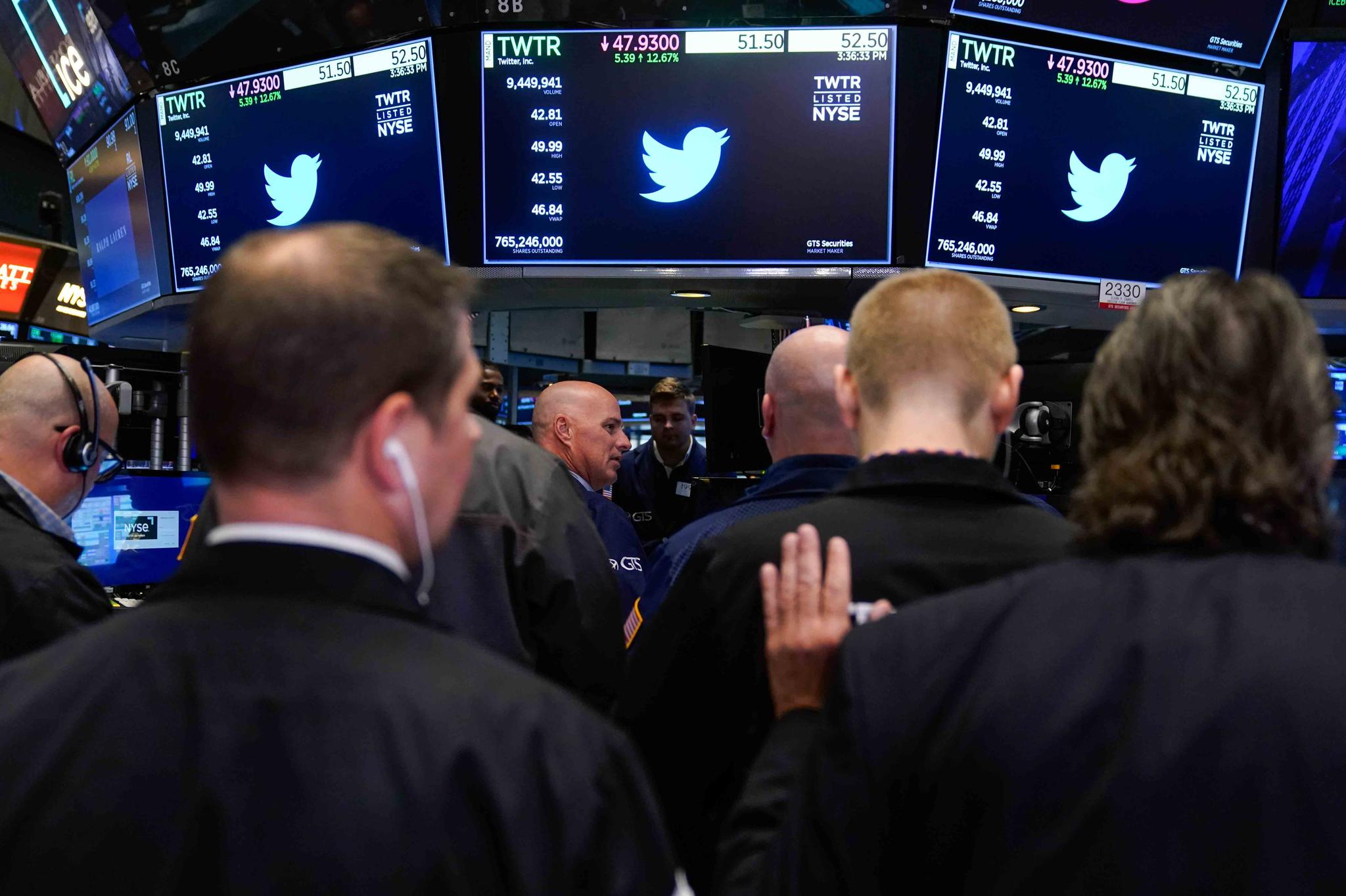Traders gather around a post as Twitter shares resume trading on the floor at the New York Stock Exchange in New York, Tuesday, Oct. 4, 2022.