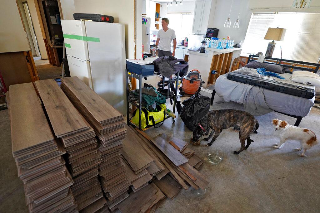 Jordan Cromer stands among water-logged items at his home in North Port, Fla.