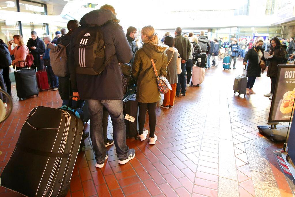 Passengers waiting in long lines.
