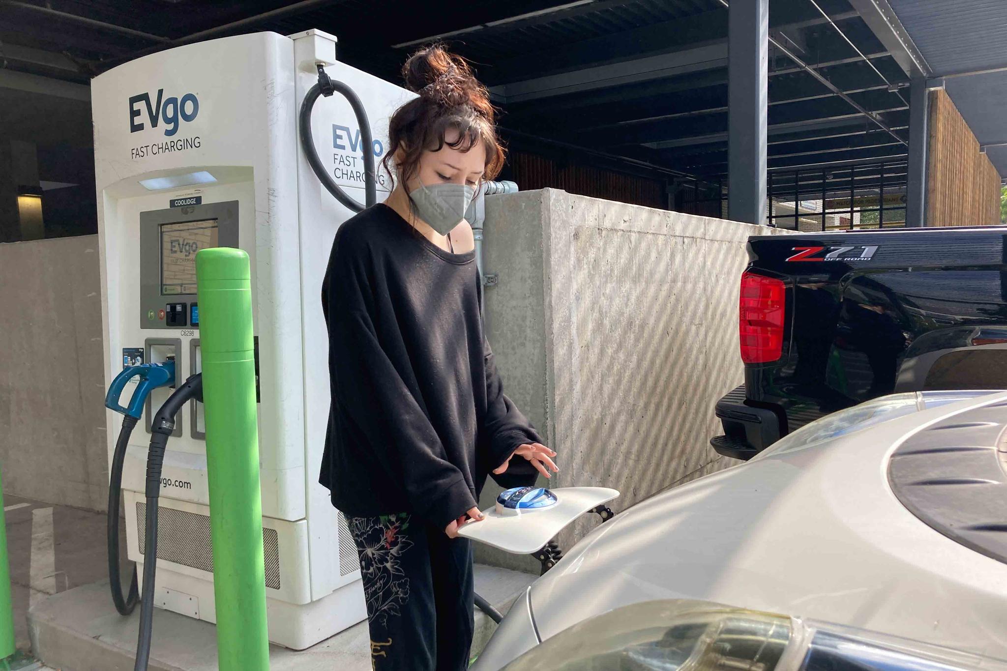 Stephanie Terrell, a Portland, Ore., renter who owns a used electric car, charges it at a public charging station in a grocery store parking lot on Sept. 30, 2022.