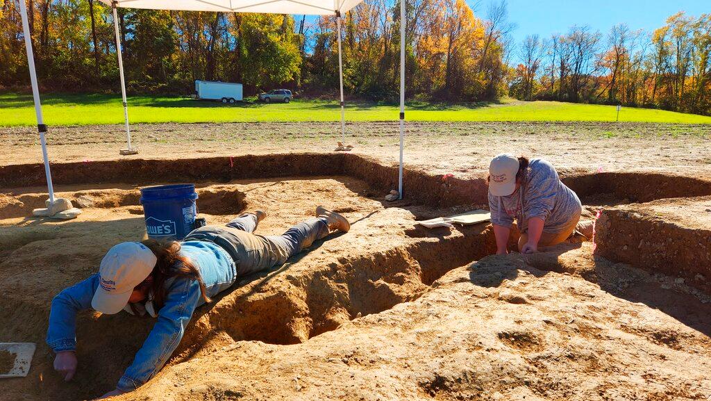  Jane C. Skinner and Samantha Muscella excavate post holes at the bottom of a stockade trench