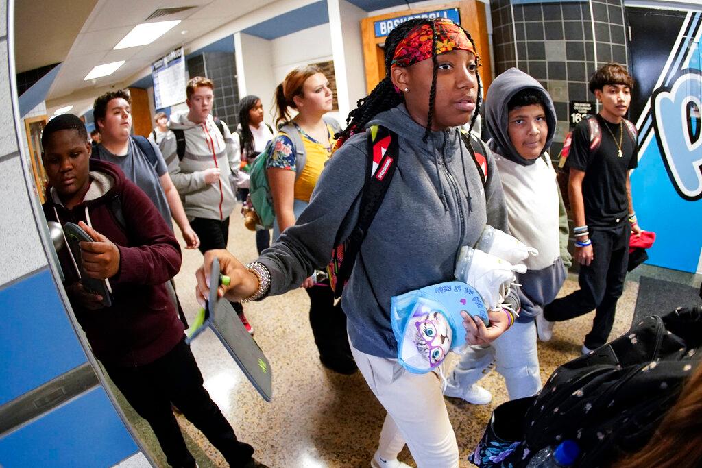 tudents at the Washington Junior High School leaving classes for the day, use the unlocking mechanism to open the bags their cell phone were sealed in during the school da