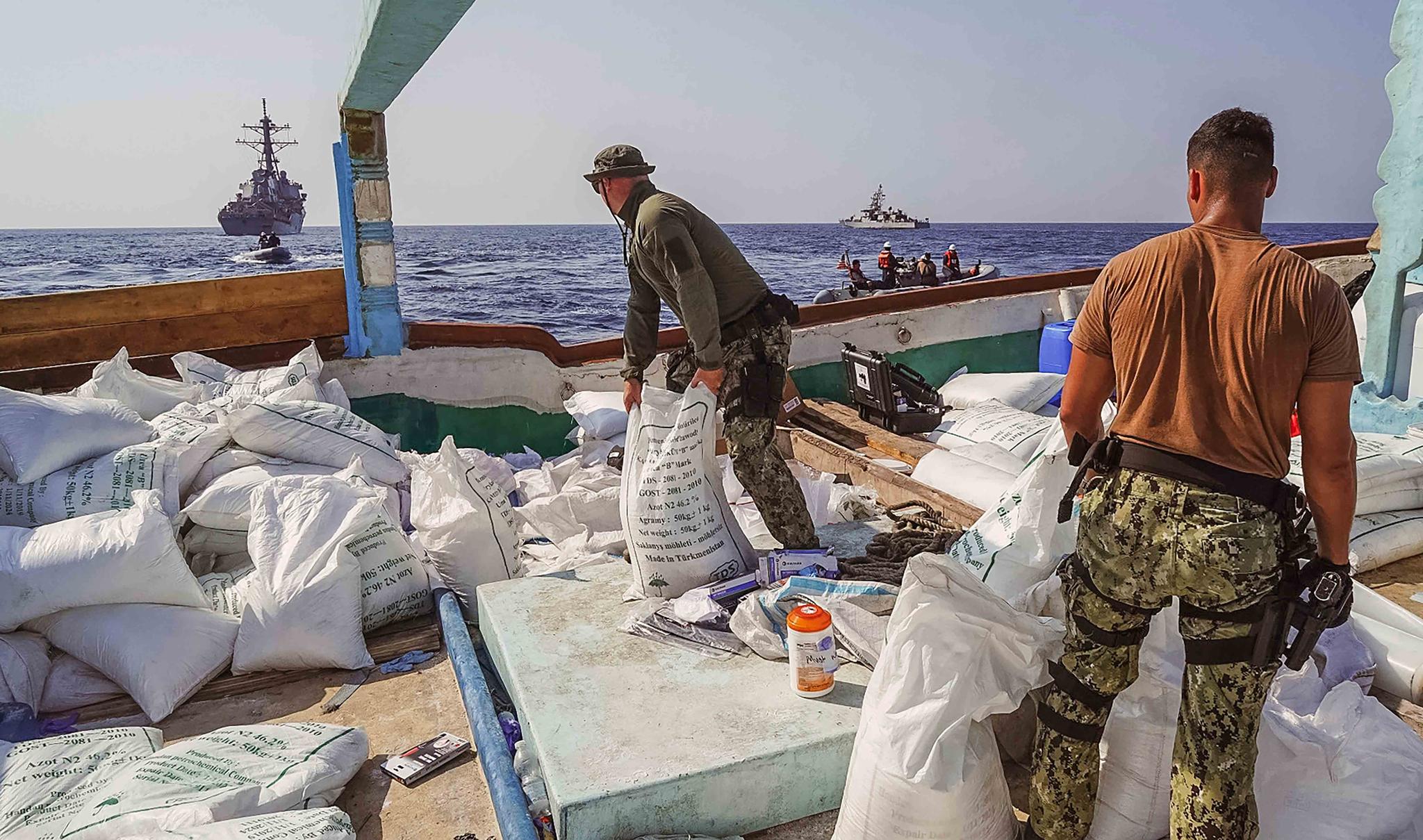 In this photo released by the U.S. Navy, sailors inventory urea and ammonium perchlorate found on a dhow intercepted in the Gulf of Oman on Nov. 9, 2022.