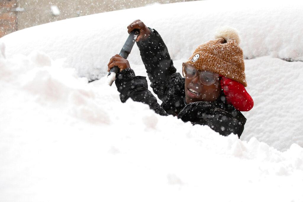 Zaria Black, 24, from Buffalo, clears off her car 