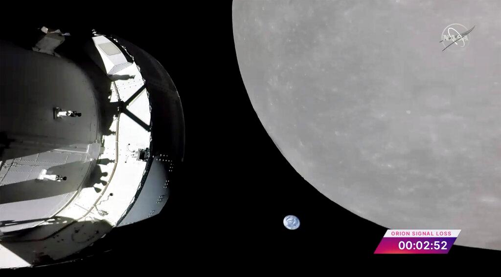 Screengrab from NASA TV shows NASA's Orion capsule, left, nearing the moon