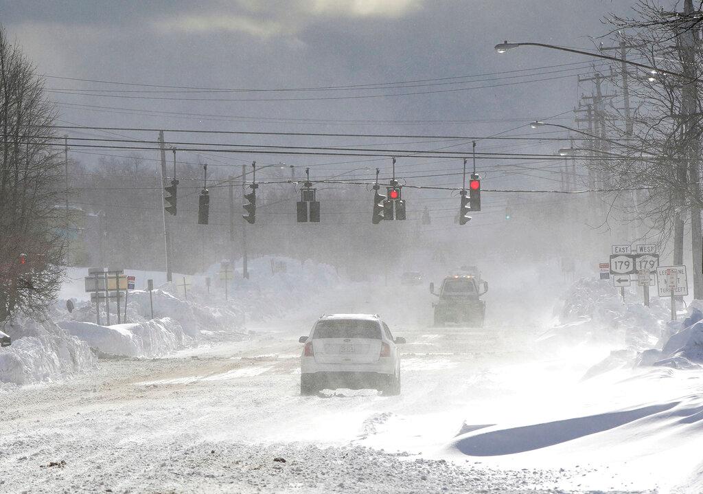 Cars drive through blowing, drifting snow on McKinley Parkway in Hamburg in Erie County, N.Y.