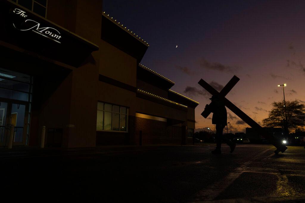 Dan Beazley carries a large wooden cross that he brought from his home in Detroit, from his car to the entrance of The Mount (Mount Lebanon Baptist Church) in Chesapeake, Va.
