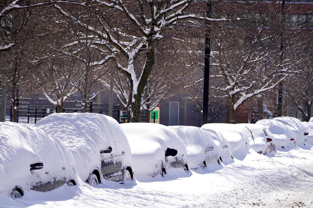 Cars parked for several days are covered in cumulative snow in Chicago