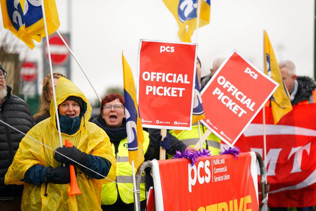 Members of the Public and Commercial Services (PCS) union on the picket line outside Birmingham Airport, England, Friday, Dec. 23, 2022. Around a quarter of a million passengers arriving at UK airports on Friday are being warned to expect delays due to the start of Border Force strikes. 