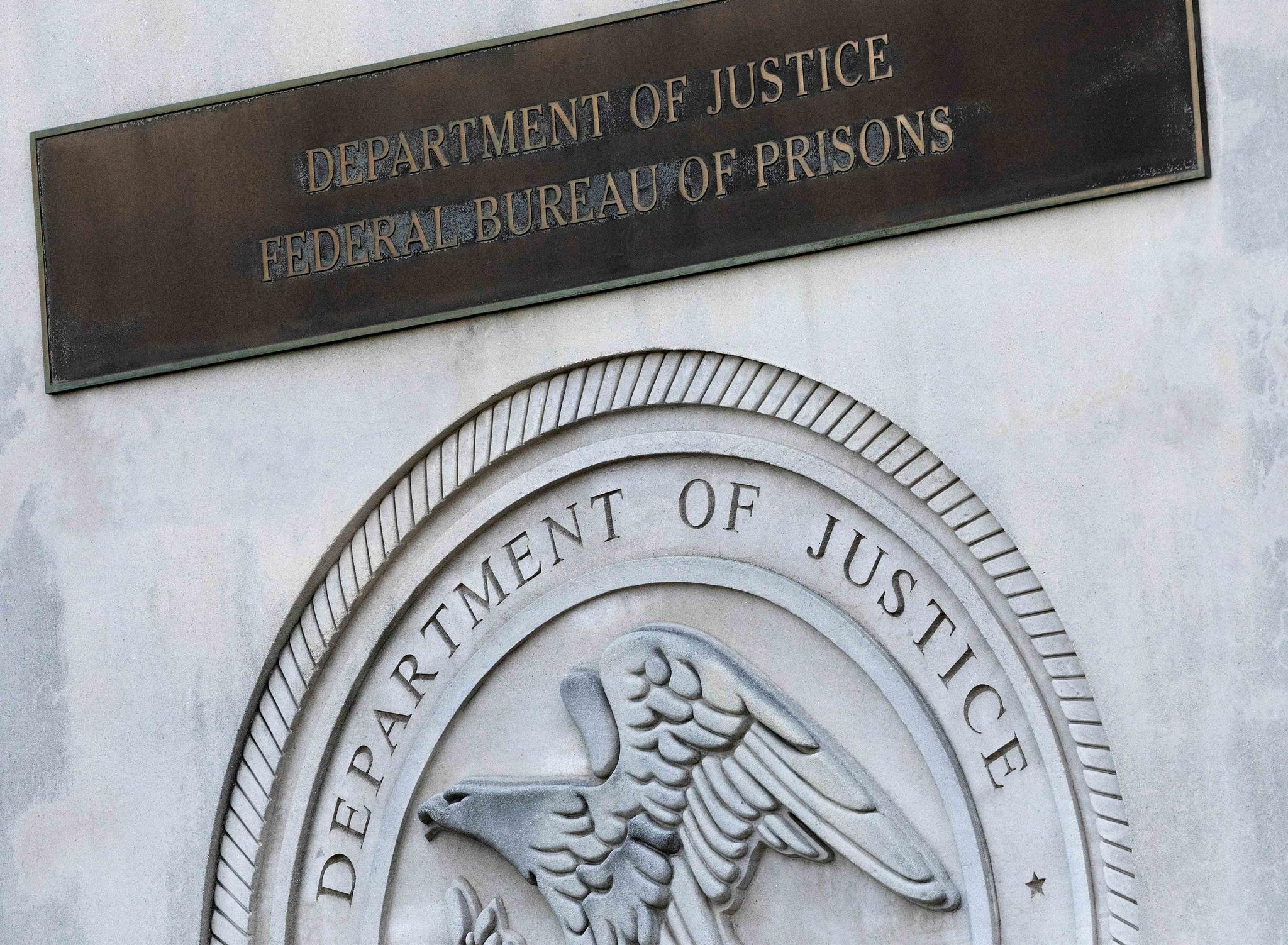 A sign for the Department of Justice Federal Bureau of Prisons is displayed in the Brooklyn borough of New York, July 6, 2020.