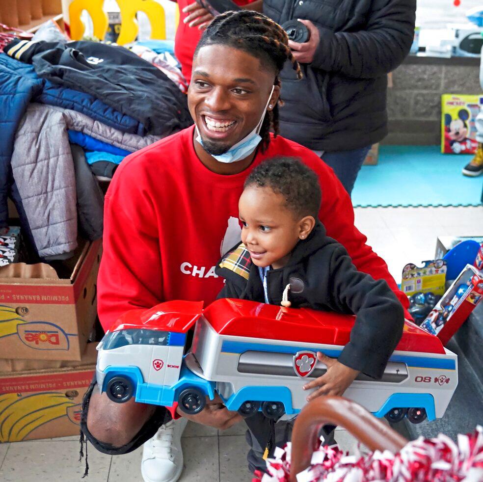 Damar Hamlin poses for a photo with Bryce Williams, 3, of McKees Rocks, Pa., after the youngster picked out a toy during Hamlin's Chasing M's Foundation community toy drive