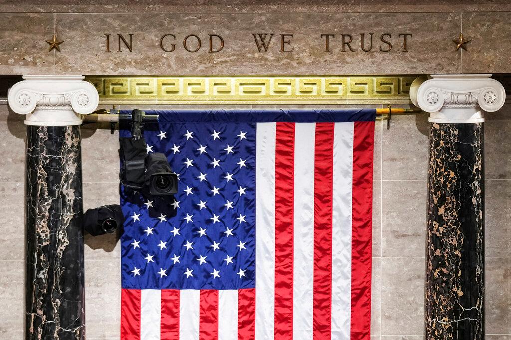"In God We Trust" is engraved in stone above a U.S. flag in the House of Representatives chamber at the Capitol in Washington 