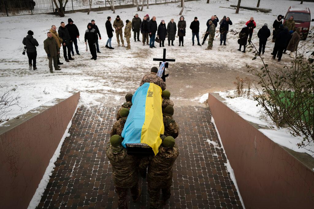 Ukrainian soldiers carrying the coffin of their fallen comrade in Bucha, Ukraine, Thursday, Jan. 12, 2023. Family members, Ukrainian soldiers, and mourners gathered to pay tribute for Volodymyr Kerbut, commander of a rifle division, killed in fighting against Russian forces on a battlefield near Soledar, the strategic town under siege on Ukraine's eastern front. 