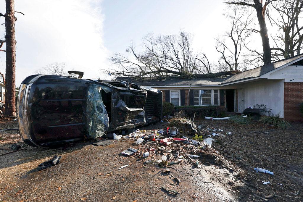A vehicle is upended and debris is strewn about follow a tornado