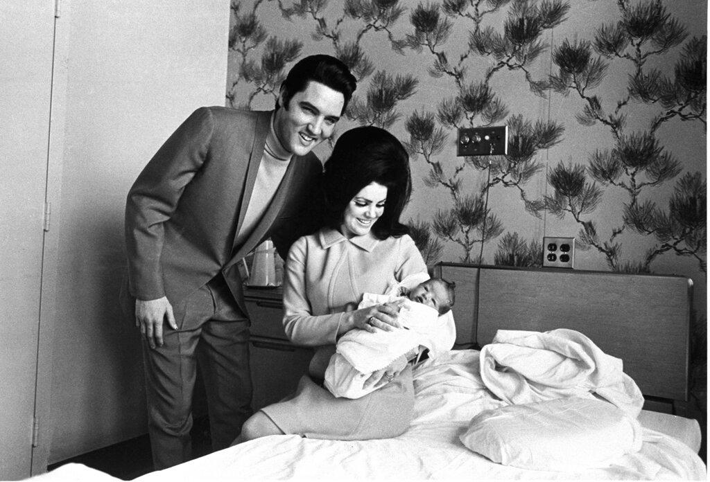 Lisa Marie Presley poses for her first picture, in the lap of her mother, Priscilla, on Feb. 5, 1968, with her father, Elvis Presley. 