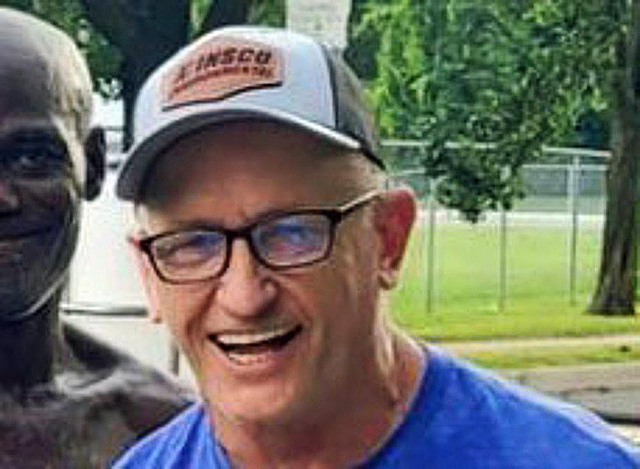 Man with ball cap and glasses on, smiling