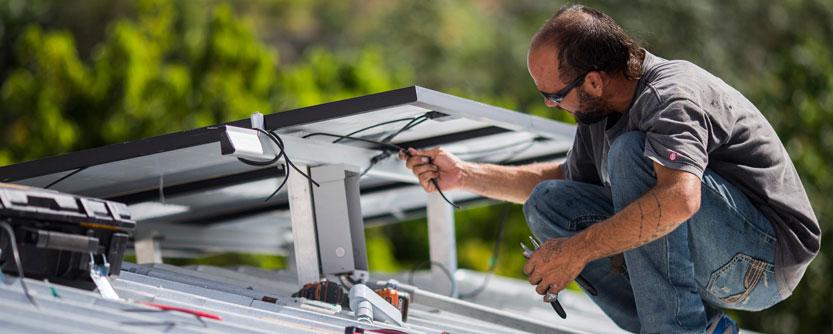 Man on a roof, installing solar panels