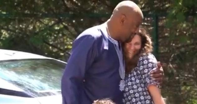 Man hugging a woman who is smiling