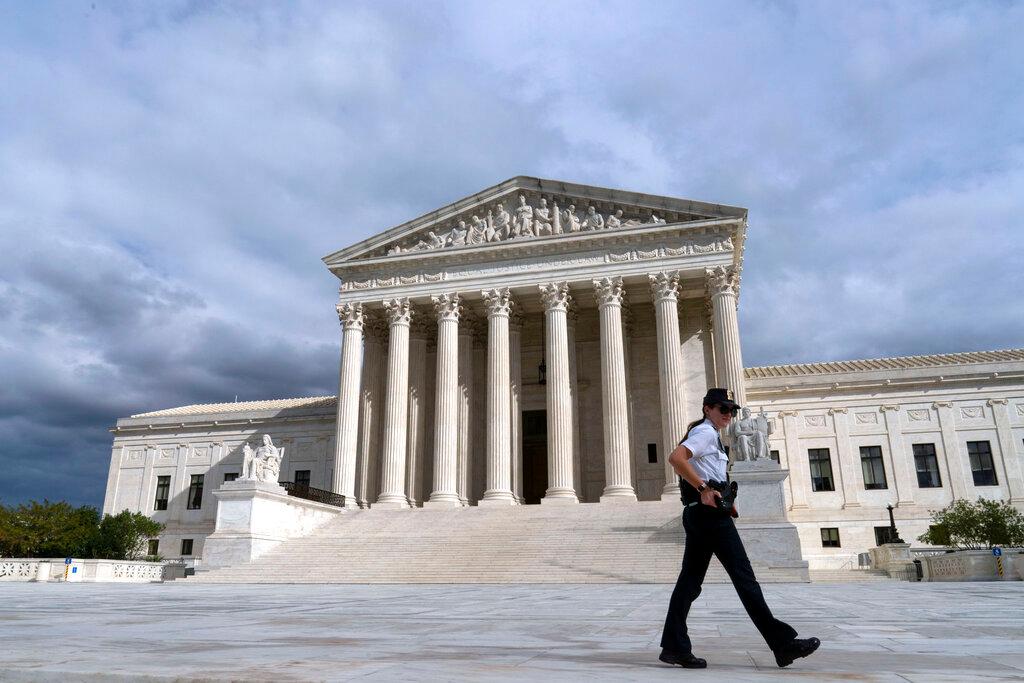 A U.S. Supreme Court police officer walks by during a voting rights rally, at the Supreme Court Oct. 28, 2021, in Washington.
