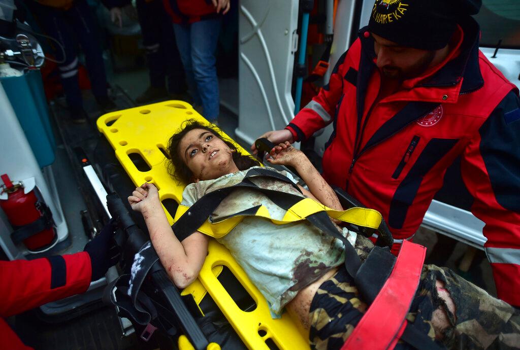 A rescuer takes care of a young girl rescued 4 days after the earthquake.