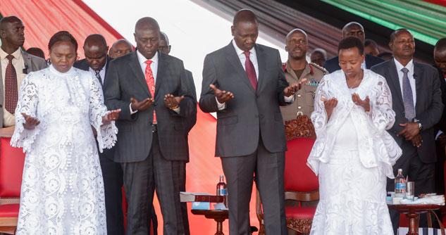 Women wearing white and men ins suits, praying
