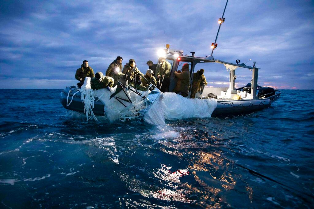 his image provided by the U.S. Navy shows sailors assigned to Explosive Ordnance Disposal Group 2 recovering a high-altitude surveillance balloon off the coast of Myrtle Beach, S.C., Feb. 5, 2023.