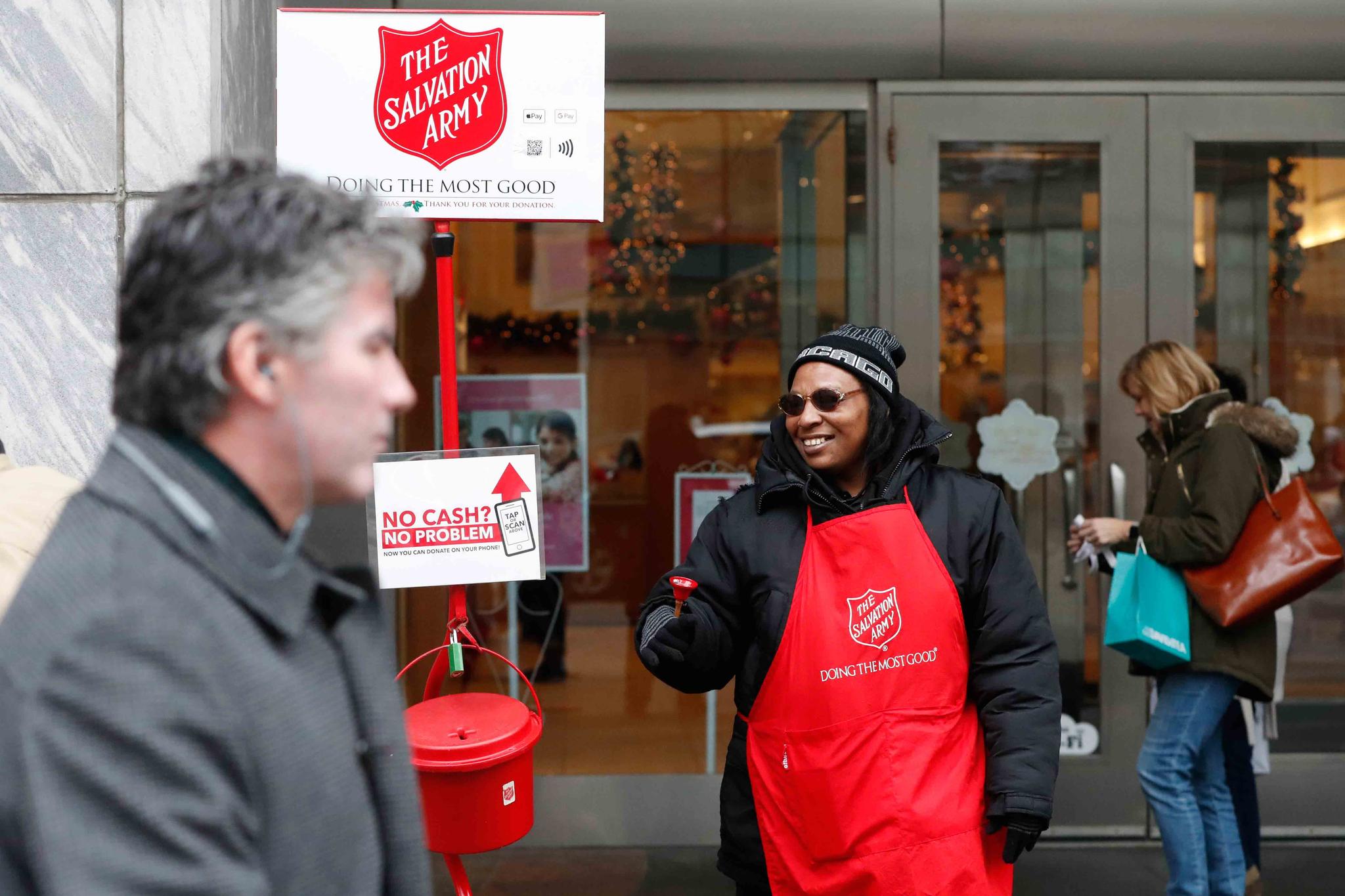 bell ringer Carolyn Harper encourages people to donate to the Salvation Army's annual holiday red kettle campaign on Chicago's Magnificent Mile