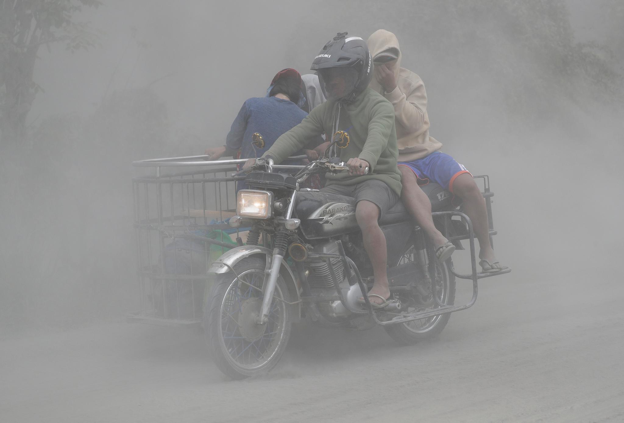 motorcycle driving as ash is falling