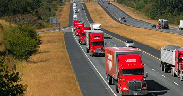 Stream of red Convoy of Hope big rigs on the freeway