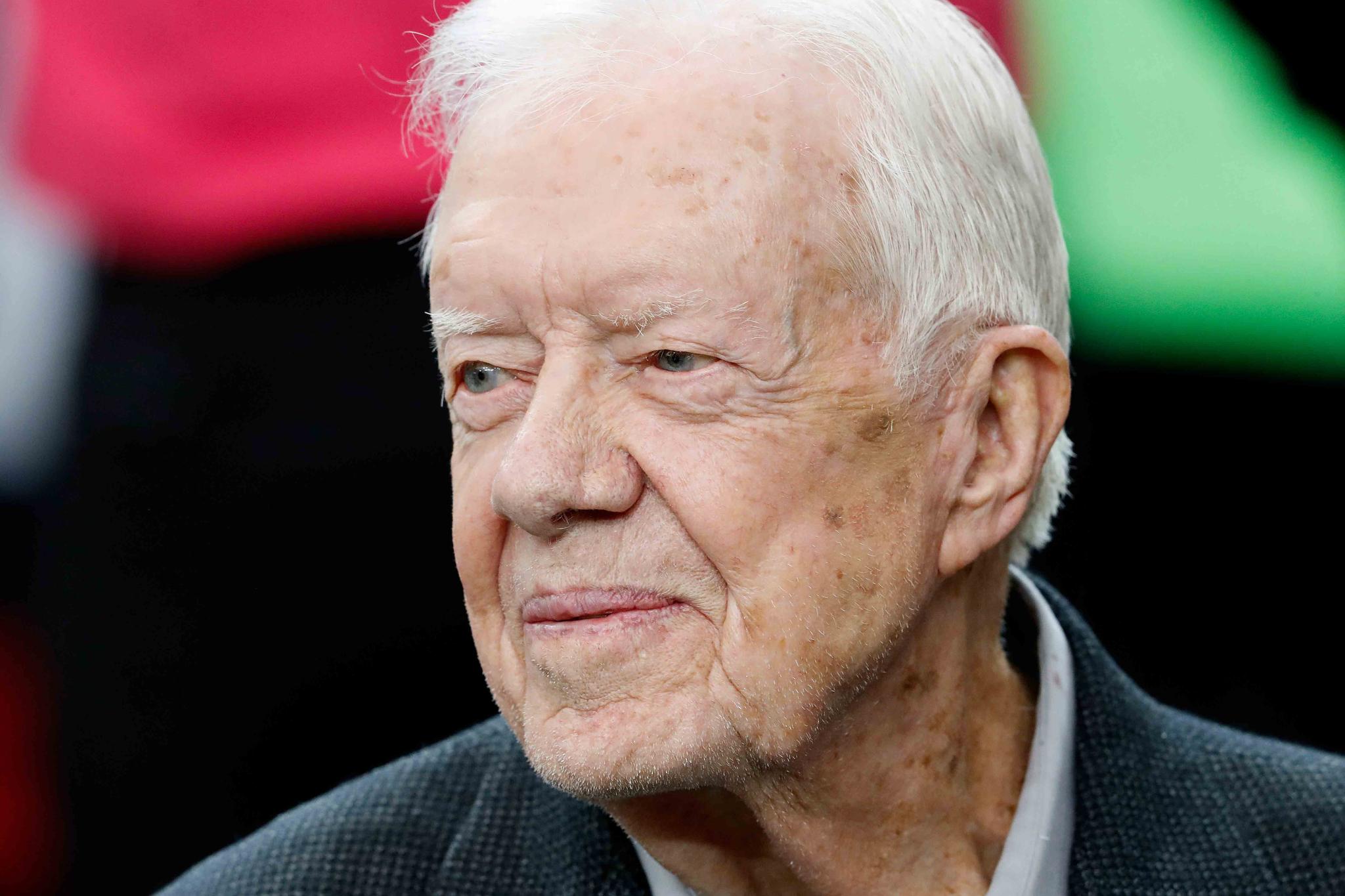 Former President Jimmy Carter sits on the Atlanta Falcons bench before the first half of an NFL football game between the Falcons and the San Diego Chargers, Sunday, Oct. 23, 2016