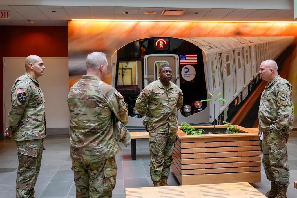 Members of the Armed Forces including the National Guard wait in the lobby of the New York City Mass Transit Authority Rail Control Center before the start of a news conference with Gov. Hochul