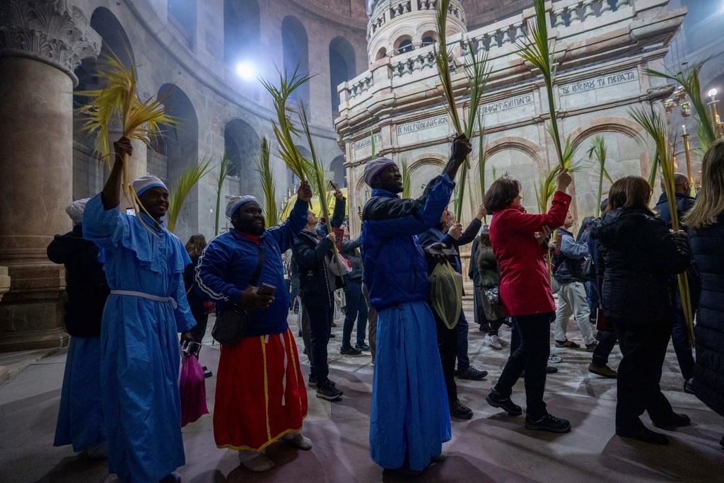 Believers carry palm fronds during the Palm Sunday procession 