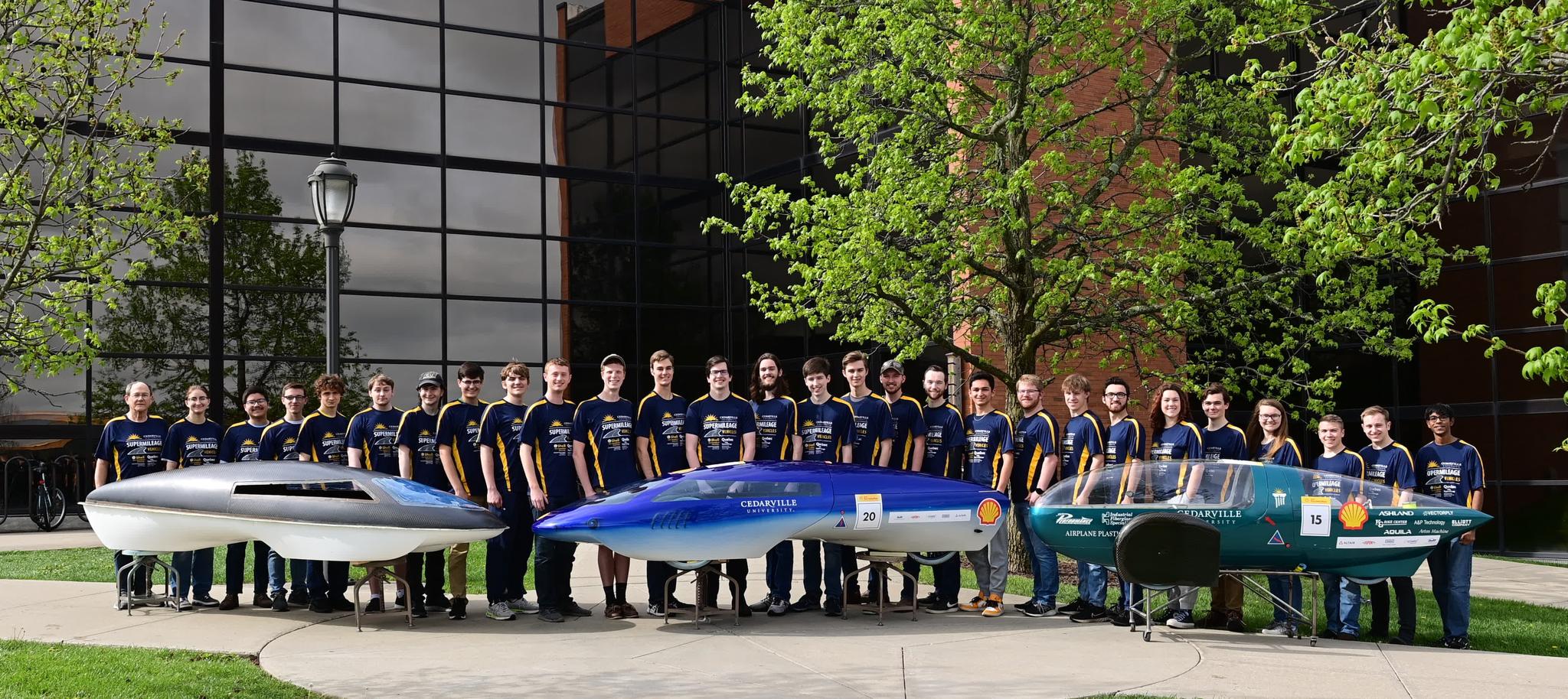 Cedarville University's 2022-23 Shell Eco-Marathon team with three of its designed cars outside of the Engineering and Science building at Cedarville University
