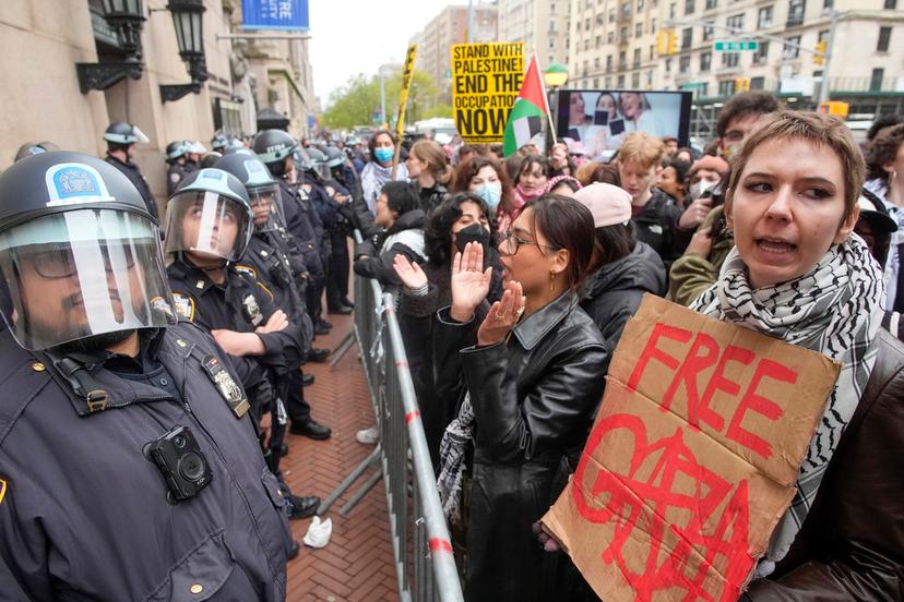 Police in Riot gear stand guard as demonstrators chant slogans outside the Columbia University campus