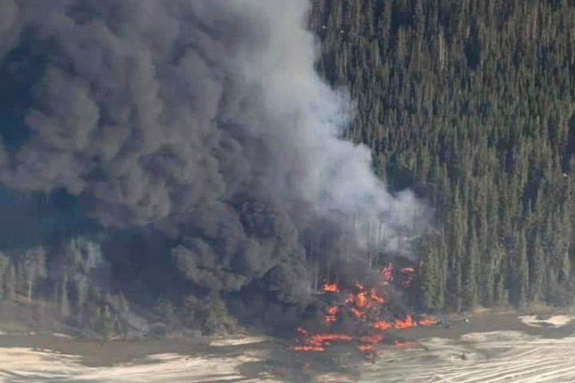 Fire burns after a Douglas C-54 Skymaster plane crashed into the Tanana River outside Fairbanks, Alaska