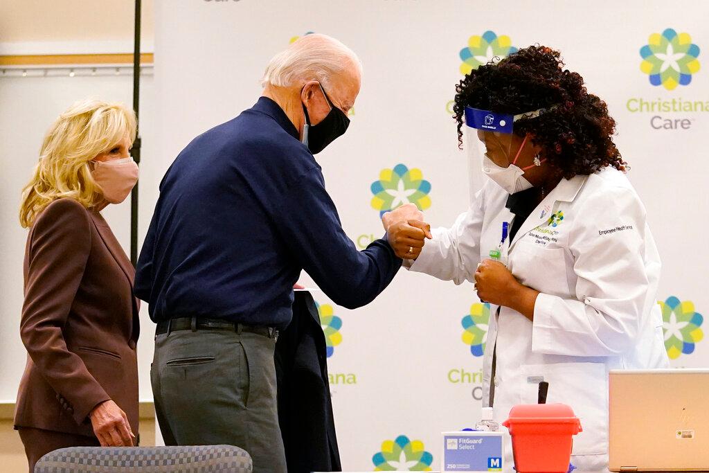 President-elect Joe Biden fist bumps with nurse practitioner Tabe Mase 